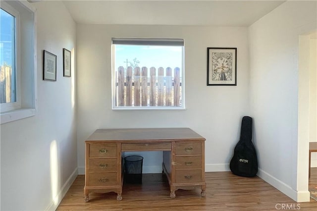 office featuring baseboards and light wood finished floors