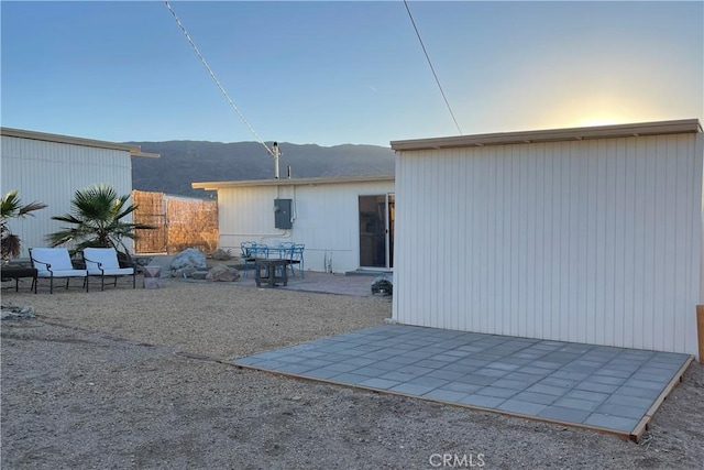 rear view of house featuring a mountain view and a patio area