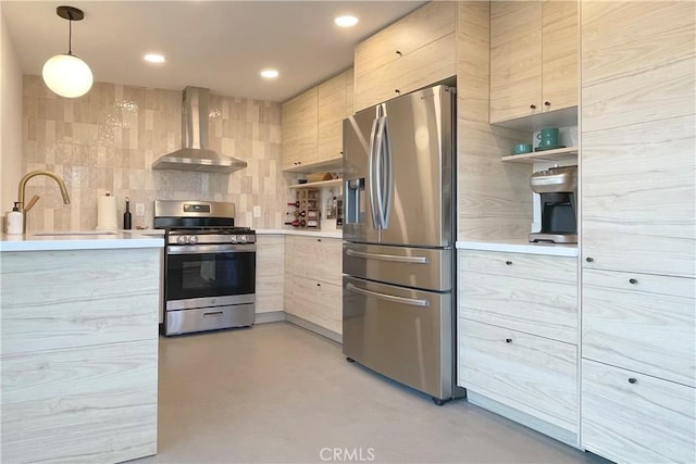 kitchen with a sink, appliances with stainless steel finishes, modern cabinets, and wall chimney exhaust hood
