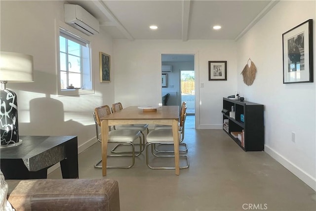dining area featuring an AC wall unit, baseboards, concrete flooring, and a healthy amount of sunlight