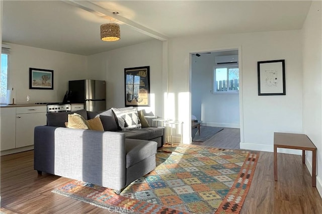 living area featuring baseboards, a wall mounted AC, and wood finished floors