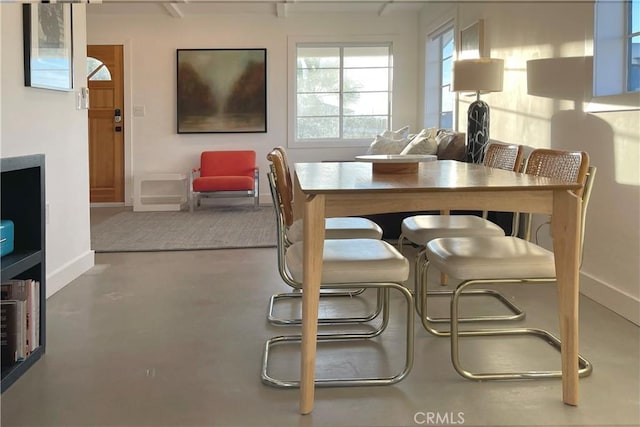 dining room with baseboards and concrete flooring