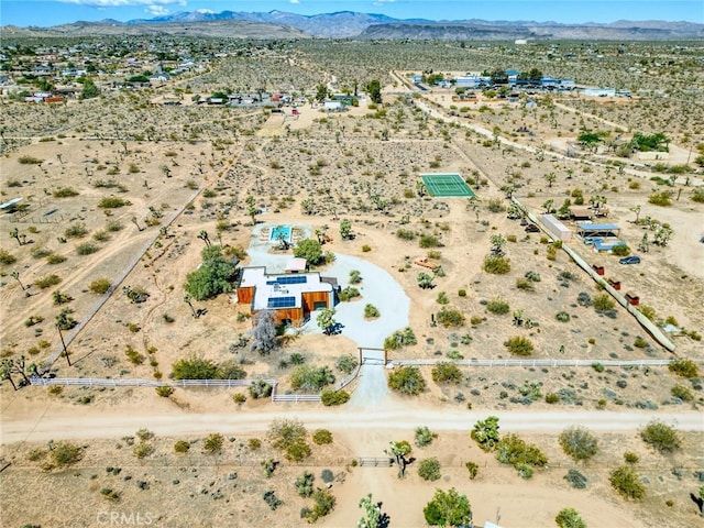 drone / aerial view featuring view of desert, a mountain view, and a rural view