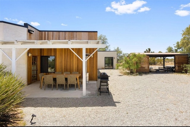 rear view of house with a patio and outdoor dining area