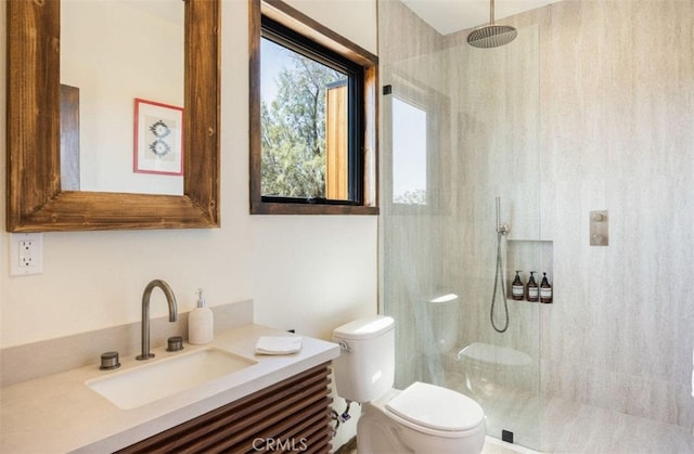 full bath featuring a walk in shower, vanity, and toilet