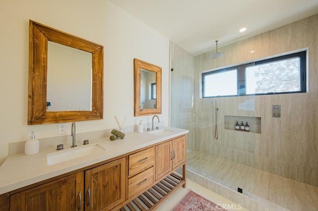bathroom featuring a sink, a walk in shower, and double vanity