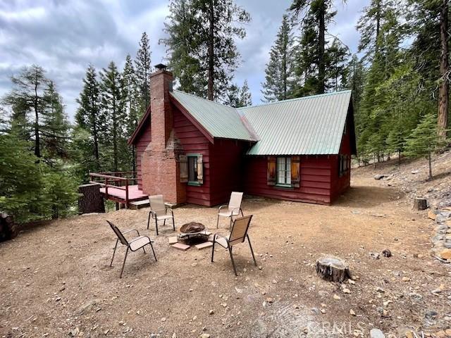 38784 Aspen Ln, Mineral, CA 96063 - back of house with a fire pit, a chimney, and metal roof