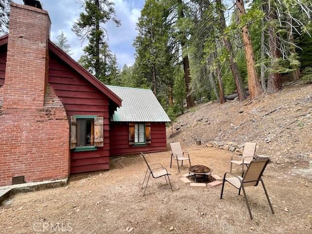 38784 Aspen Ln, Mineral, CA 96063 - view of property exterior featuring a fire pit, a chimney, and metal roof
