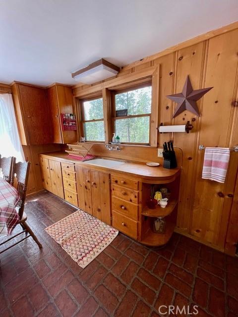 38784 Aspen Ln, Mineral, CA 96063 - kitchen featuring brick flooring, open shelves, and a sink