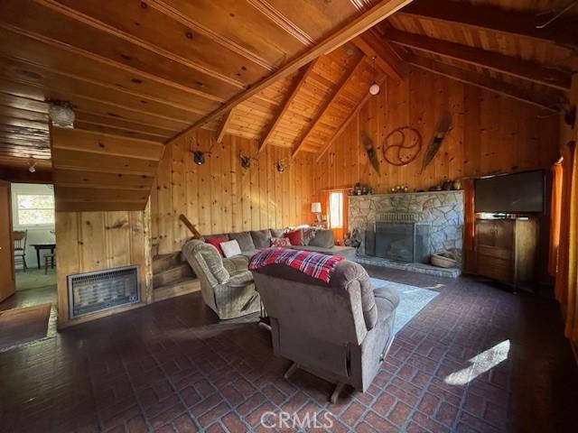 38784 Aspen Ln, Mineral, CA 96063 - living room featuring a fireplace, wooden walls, brick patterned floors, and wooden ceiling