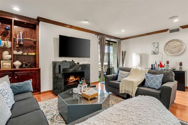 450 N Oakhurst Dr Unit 304, Beverly Hills, CA 90210 - living area with ornamental molding, wood finished floors, a high end fireplace, baseboards, and recessed lighting