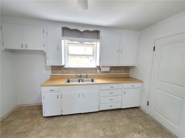 904 Toomes Ave, Corning, CA 96021 - kitchen featuring a sink, light countertops, white cabinetry, and decorative backsplash