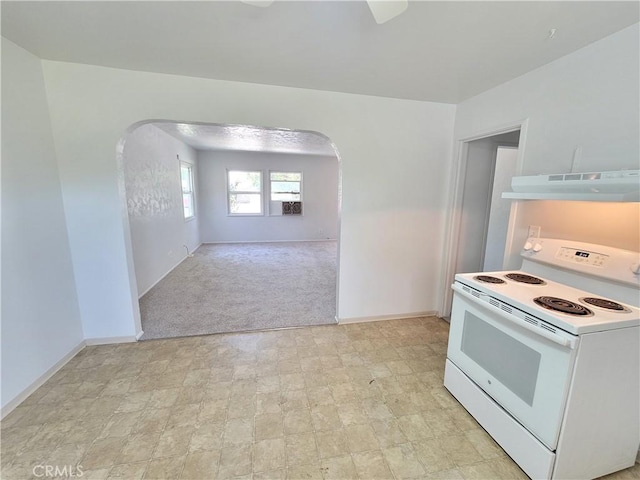 904 Toomes Ave, Corning, CA 96021 - kitchen featuring white electric stove, under cabinet range hood, arched walkways, baseboards, and light carpet