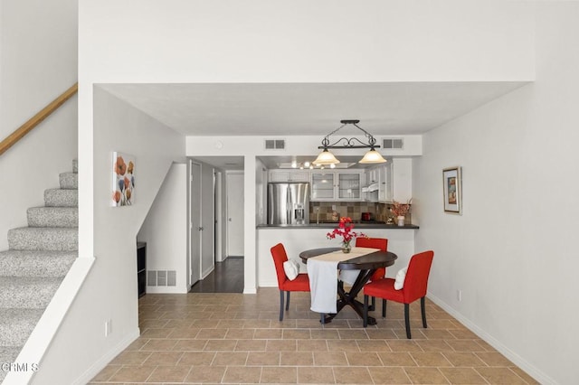 dining space with visible vents, stairs, and baseboards