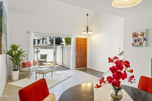 tiled living area featuring baseboards, a notable chandelier, and high vaulted ceiling