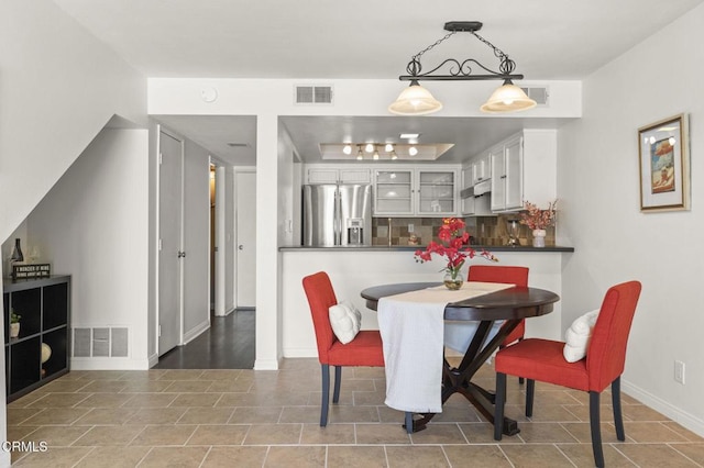 tiled dining space featuring visible vents and baseboards