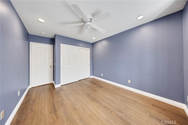 unfurnished bedroom with a ceiling fan, baseboards, recessed lighting, wood finished floors, and a closet