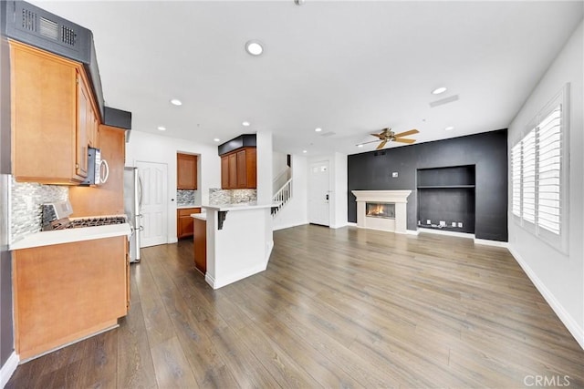 kitchen with ceiling fan, a kitchen breakfast bar, visible vents, open floor plan, and stainless steel appliances