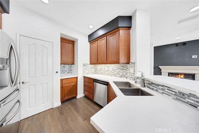kitchen with backsplash, dark wood-style flooring, visible vents, a sink, and stainless steel appliances