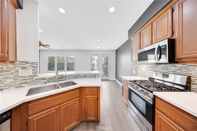 kitchen featuring plenty of natural light, a sink, light wood-style floors, and stainless steel appliances