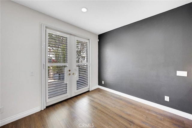 interior space with baseboards, french doors, and wood finished floors