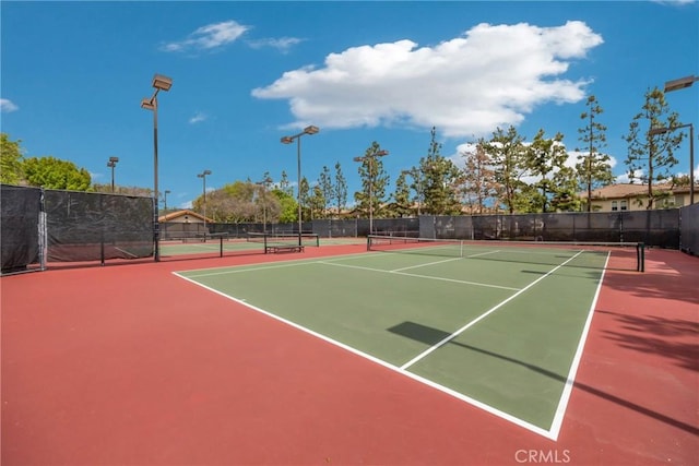 view of tennis court with fence and community basketball court