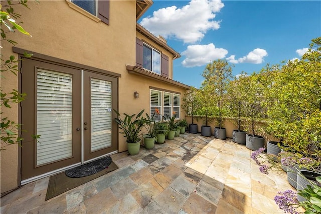 property entrance with french doors, a patio area, and stucco siding