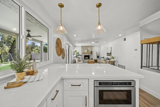 223 Cottingham Ct, Oceanside, CA 92054 - kitchen with ceiling fan, a peninsula, white cabinets, stainless steel oven, and recessed lighting