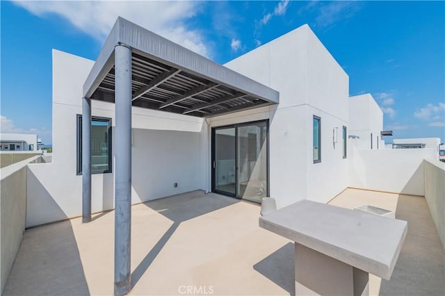 back of house with a patio and stucco siding