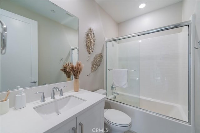 bathroom featuring bath / shower combo with glass door, vanity, and toilet