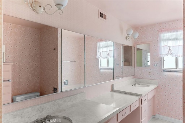 bathroom with wallpapered walls, visible vents, and a wealth of natural light