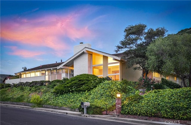 property exterior at dusk featuring a chimney