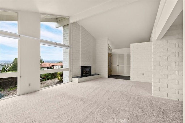 unfurnished living room featuring a healthy amount of sunlight, carpet floors, and a large fireplace
