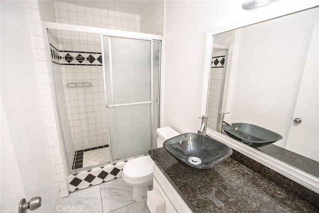bathroom with vanity, marble finish floor, toilet, and a shower stall