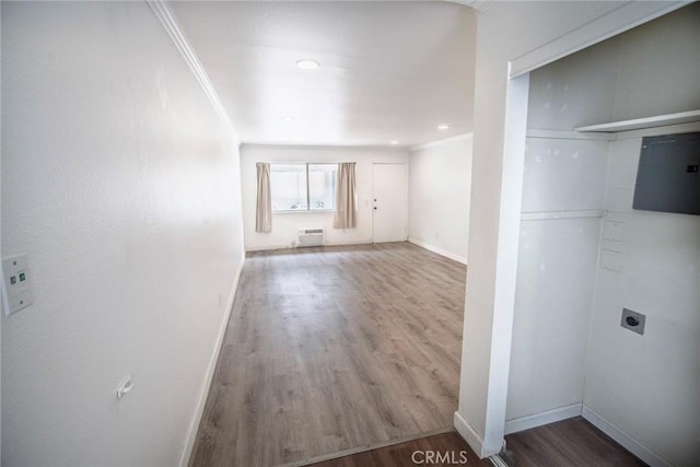 interior space featuring crown molding, recessed lighting, baseboards, a wall unit AC, and wood finished floors