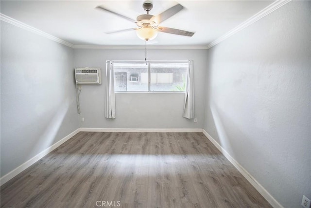 spare room featuring a ceiling fan, a wall mounted AC, wood finished floors, baseboards, and ornamental molding