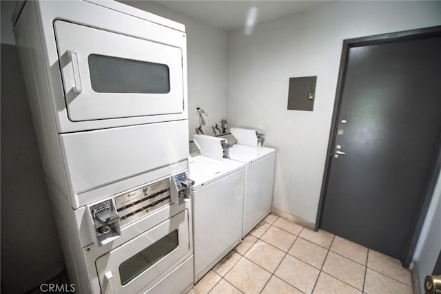 common laundry area with stacked washer and dryer and light tile patterned floors