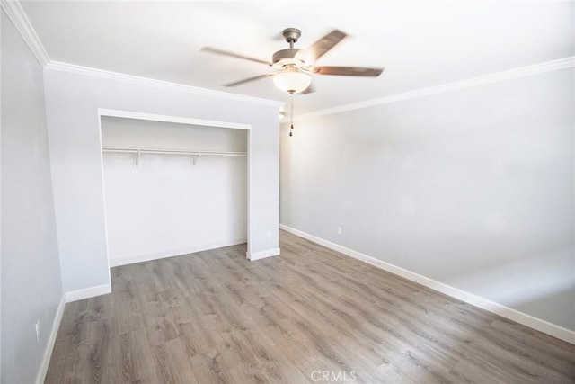 unfurnished bedroom with crown molding, baseboards, and wood finished floors