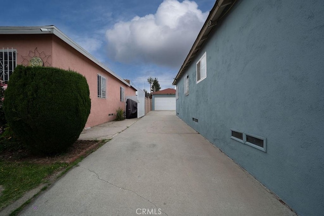1125 W 129th St, Gardena, CA 90247 - view of side of home featuring crawl space, a garage, an outdoor structure, and stucco siding