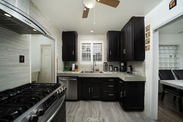 1125 W 129th St, Gardena, CA 90247 - kitchen with a sink, dishwasher, stainless steel range with gas stovetop, dark cabinetry, and range hood