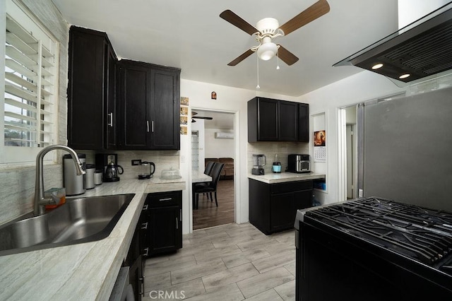 1125 W 129th St, Gardena, CA 90247 - kitchen with ceiling fan, ventilation hood, a sink, dark cabinetry, and gas range
