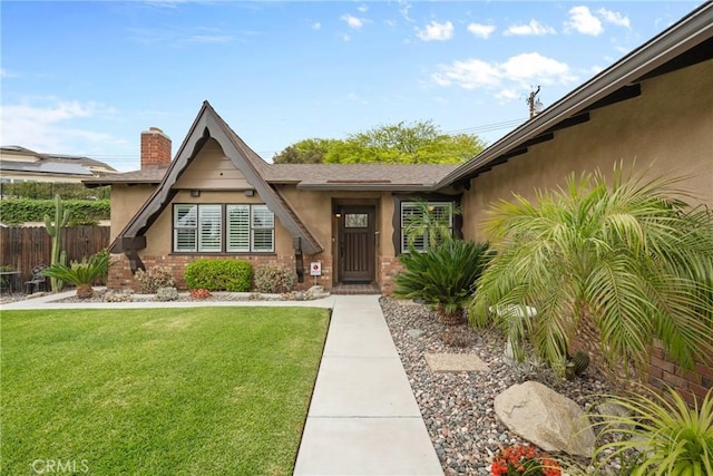 1131 Saint George Dr, San Dimas, CA 91773 - view of exterior entry with a lawn, fence, a chimney, and stucco siding