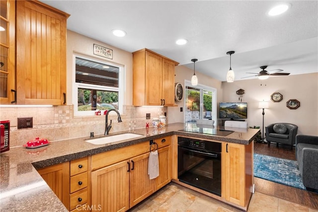 1131 Saint George Dr, San Dimas, CA 91773 - kitchen with a sink, a peninsula, open floor plan, decorative backsplash, and black appliances