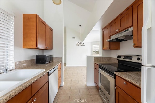 12555 Euclid St Unit 72, Garden Grove, CA 92840 - kitchen with brown cabinetry, light tile patterned flooring, under cabinet range hood, a chandelier, and appliances with stainless steel finishes