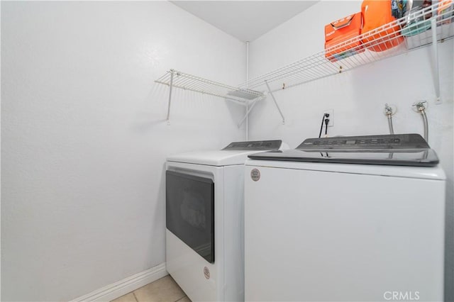laundry room with laundry area, baseboards, independent washer and dryer, and light tile patterned floors