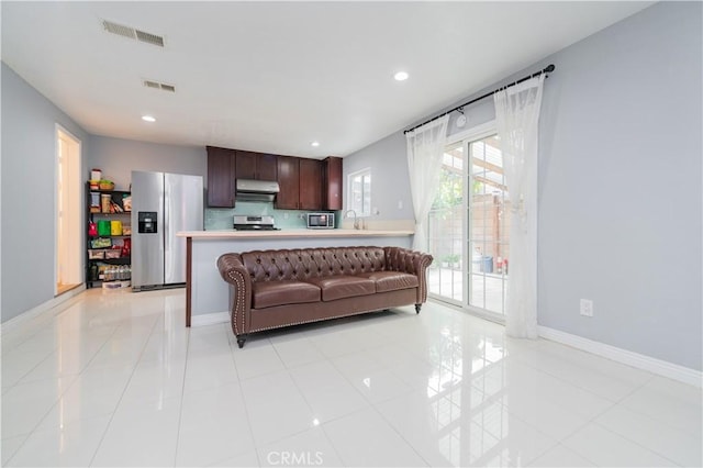 living area with baseboards, recessed lighting, and visible vents