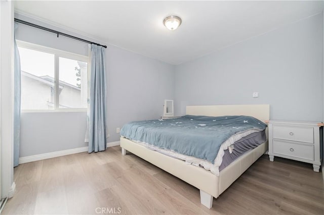 bedroom featuring baseboards and wood finished floors