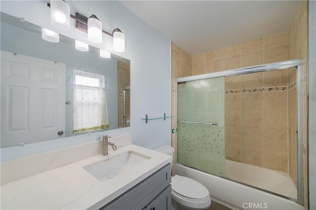 full bath featuring bath / shower combo with glass door, vanity, and toilet