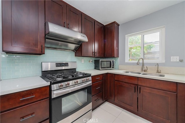 kitchen with a sink, appliances with stainless steel finishes, under cabinet range hood, and light countertops