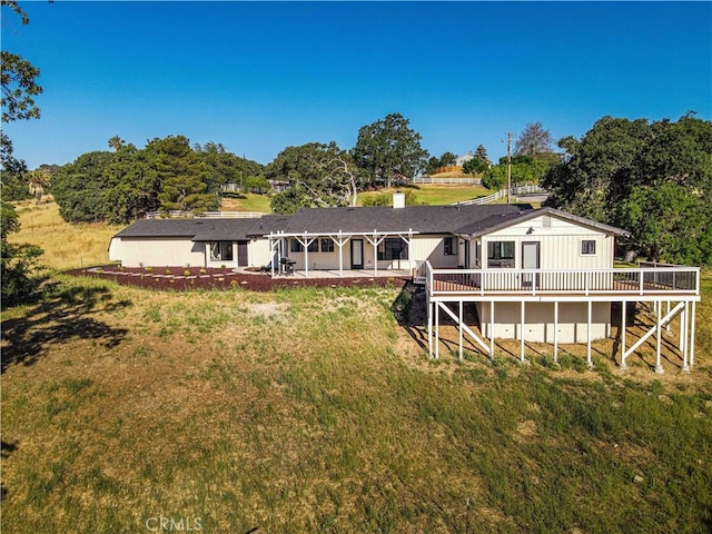 rear view of house with a deck, a yard, and a patio